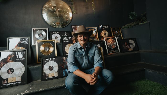 Zach Top, flanked by RIAA Platinum and Gold records. Photo Credit: Hunter Hart |
